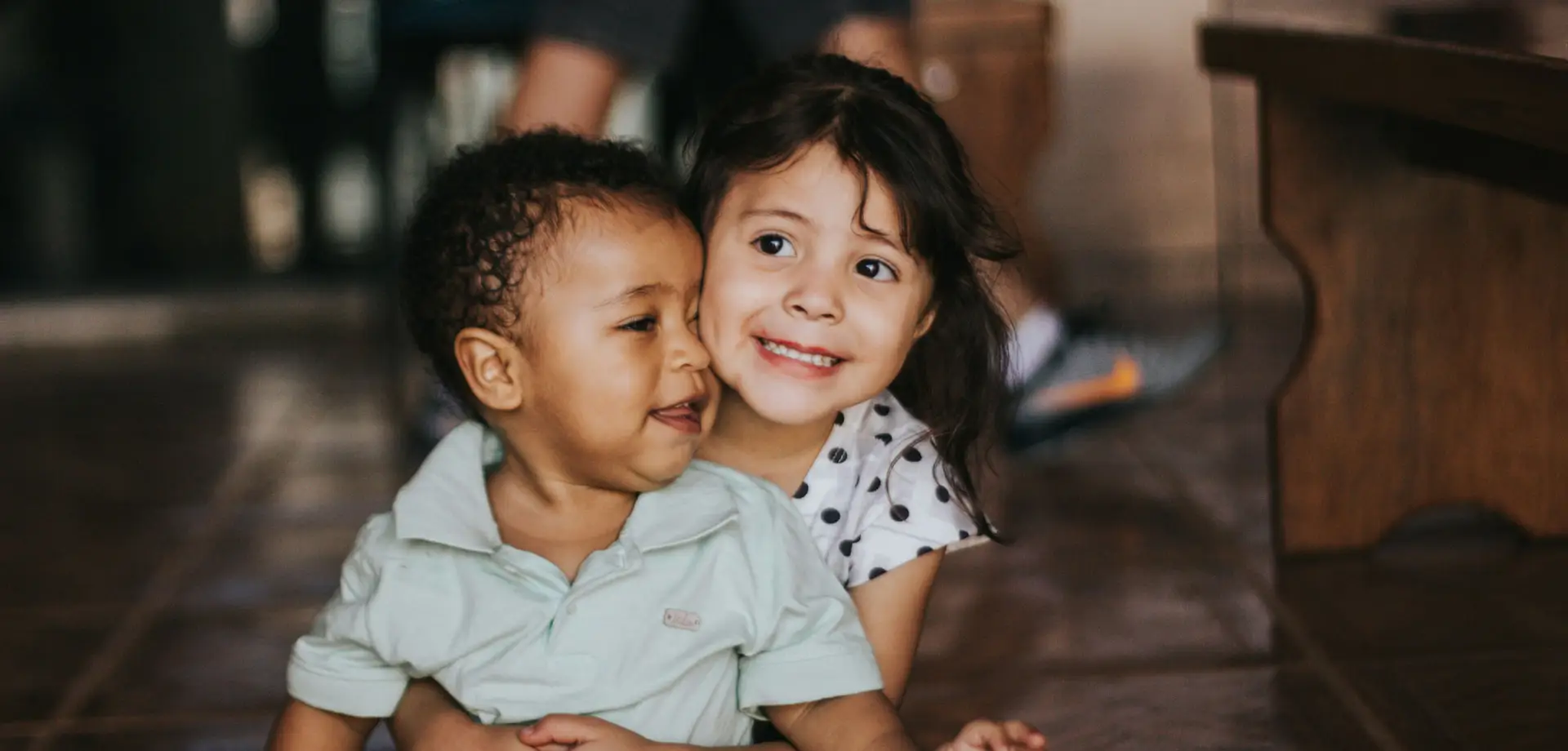 two small children sitting on the floor together